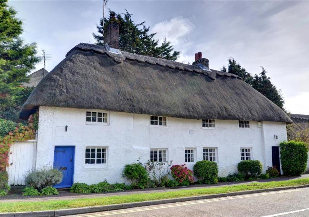 stary biały dom z dachem krytym strzechą w obiekcie Thatch Cottage w mieście Shoreham-by-Sea