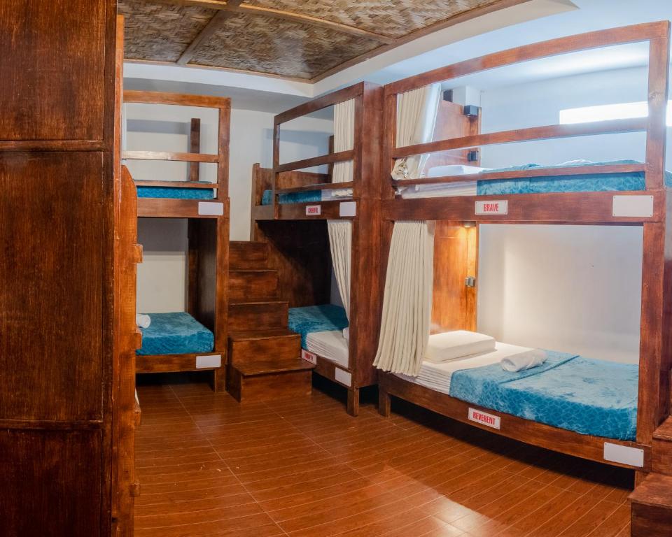 a room with three bunk beds in a house at Public House Hostel in Pusok