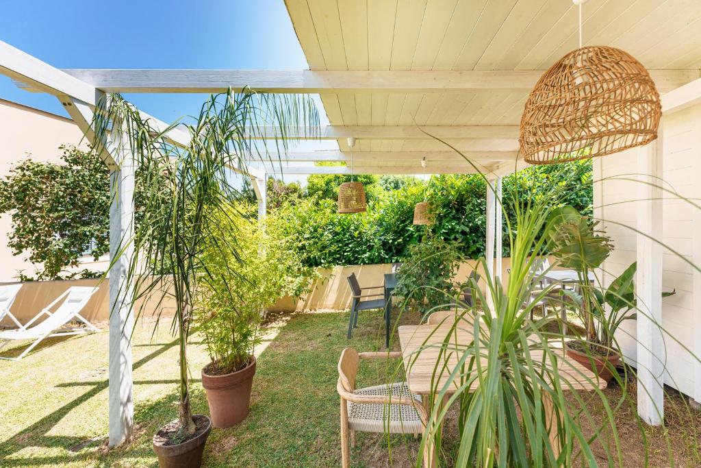 un patio con mesa, sillas y plantas en Villa Mazzella, en Procida