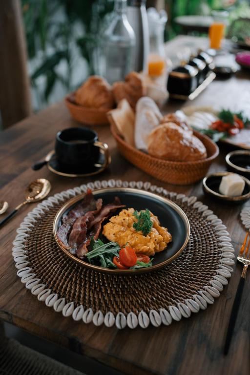 a plate of food on a wooden table with bread at EHOA BALI Nyanyi Boutique Hotel - In front of entrance to NUANU in Tanah Lot