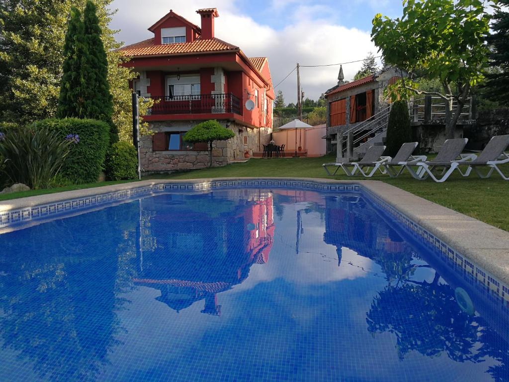 a swimming pool in front of a house at Villa Pazos in Nigrán