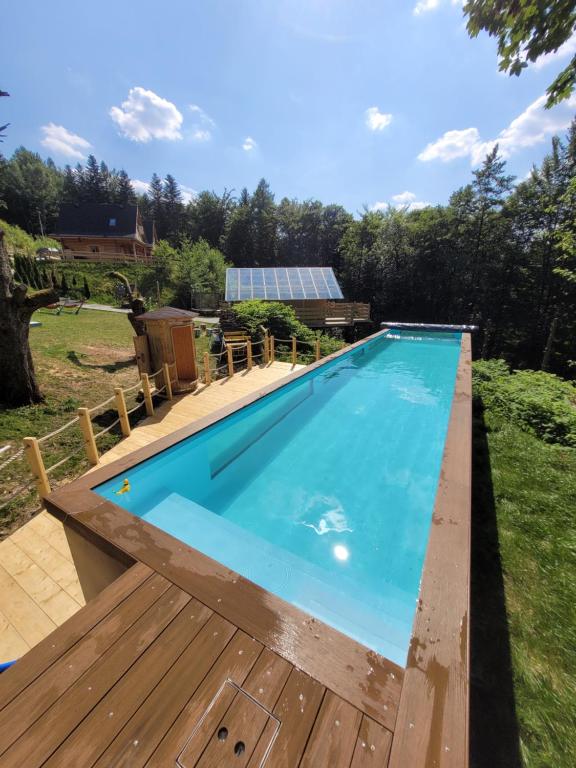 una gran piscina con terraza de madera y piscina en Cicha Polana en Szczyrk