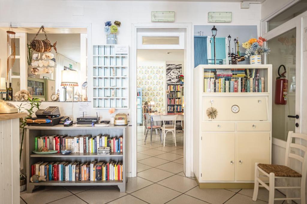a kitchen with book shelves filled with books at Piccolo Hotel Kursaal in Cesenatico
