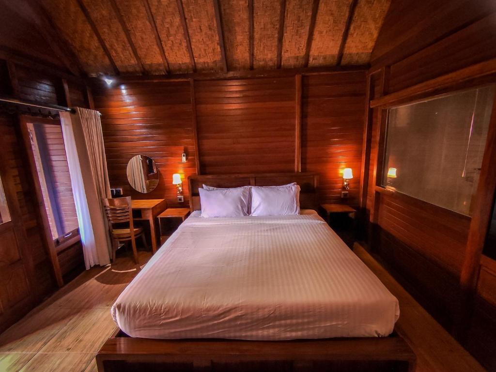 een slaapkamer met een bed in een houten kamer bij Uli Wood Villa, Jimbaran BALI - near GWK in Jimbaran