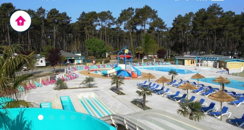 een zwembad in een resort met stoelen en een waterpark bij les Dunes de Contis in Saint-Julien-en-Born