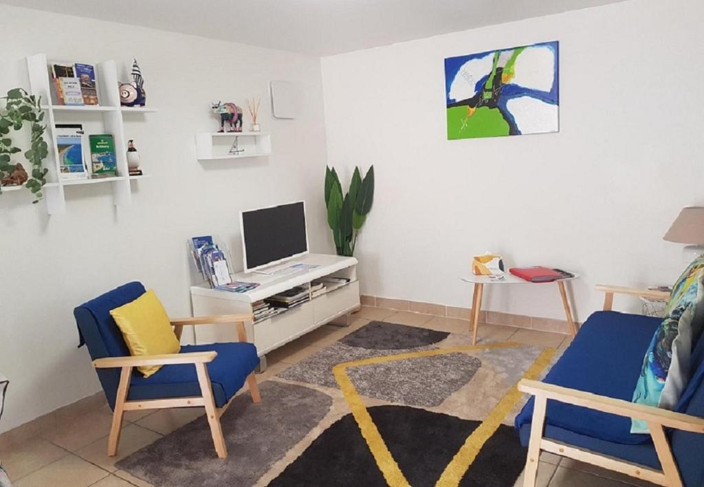 sala de estar con 2 sillas y TV en Appartement T3 meublé, St Evarzec Bretagne - Le Degemer-Mat, en Saint-Évarzec