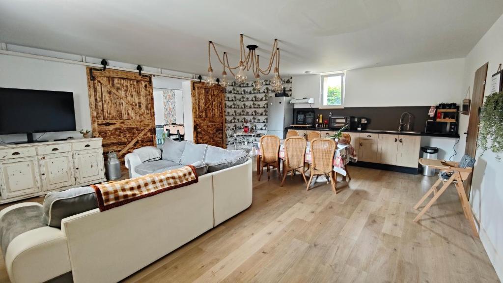 a living room with a couch and a dining room at Entre terres et mer chez Carméla in Bazinghen