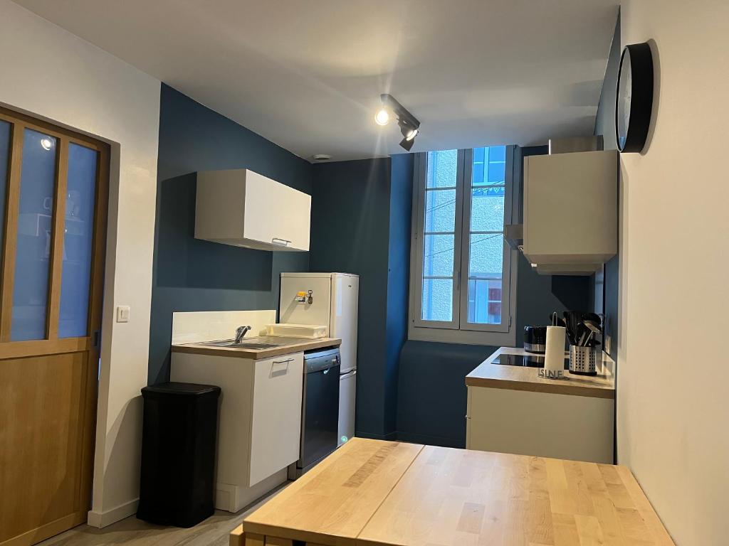 una cucina con pareti blu ed elettrodomestici bianchi di Très bel appartement Cauterets centre 6 places a Cauterets
