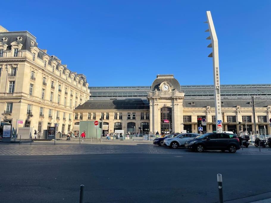 um grande edifício com carros estacionados em frente em Appartement cozy à 100m de la gare Saint Jean em Bordeaux