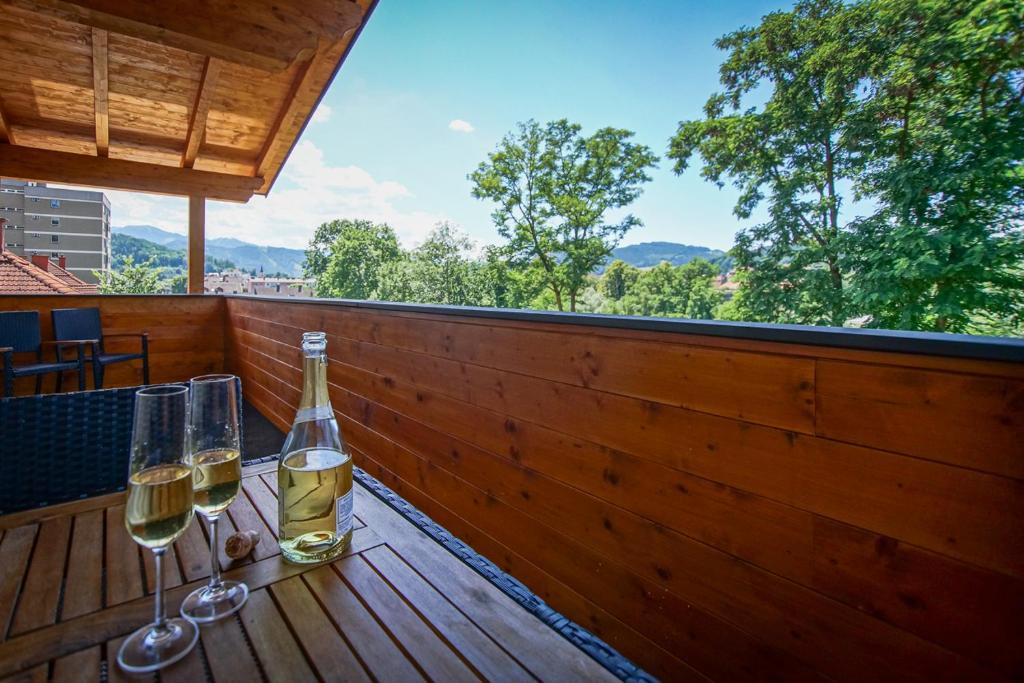 a table with two glasses of wine on a deck at AusZeit Steiraland Penthouse 9 mit großen Balkon und Parkplatz in Leoben