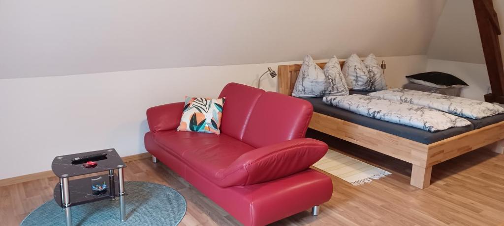 - un salon avec une chaise rouge et un lit dans l'établissement Appartement Gertraud, à Hieflau