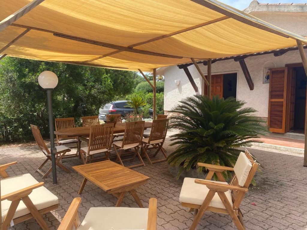 a wooden table and chairs under a yellow umbrella at Casa Trecci in Albinia