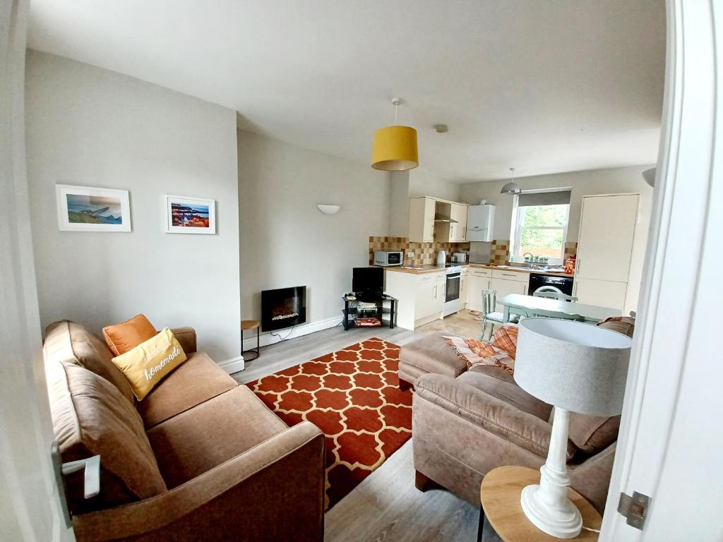 a living room with a couch and a table at Serendipity cottage in Castleton