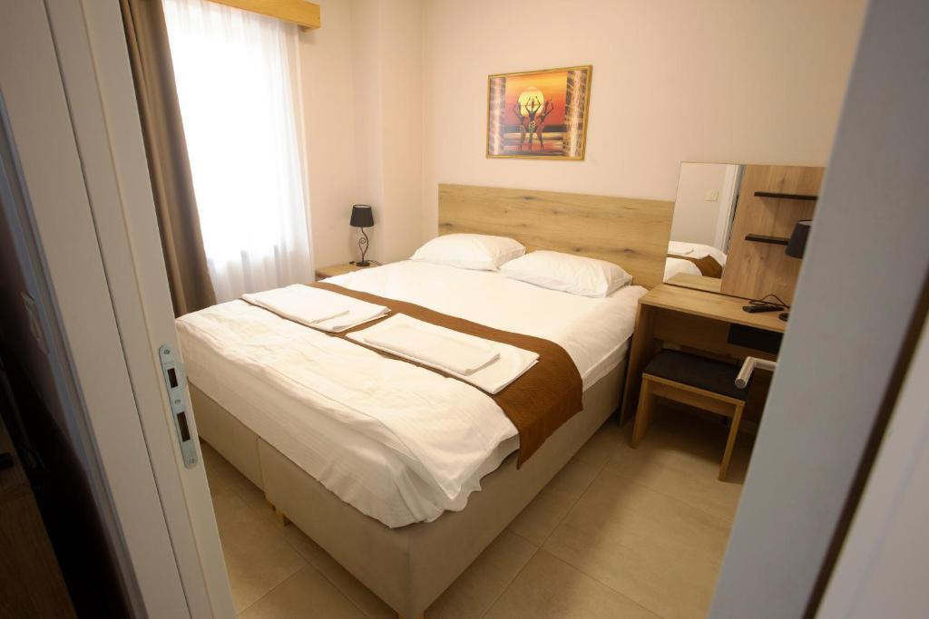 a bedroom with a bed and a desk with a window at Soul Food River Hotel e cucina in Pančevo