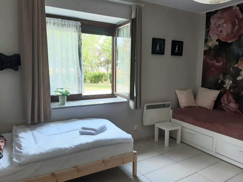 a bedroom with a bed and a window at Apartamenty Rodzinne Pilica PARK in Sulejów