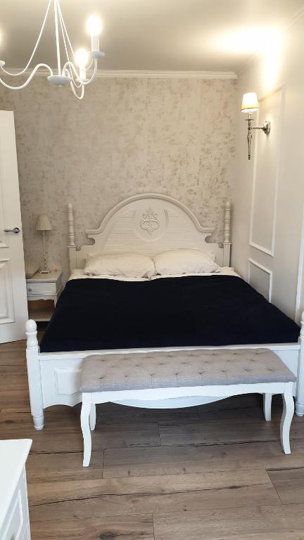 a bedroom with a white bed with a black blanket at Stylowy apartament ARMINA in Szczytno
