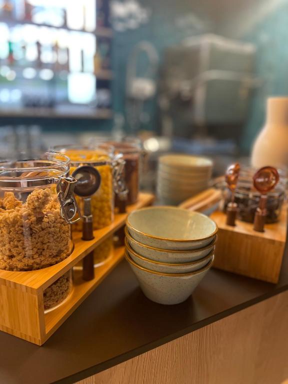 a counter with bowls and dishes on a shelf at Hôtel Restaurant BO &amp; MIA in La Baule