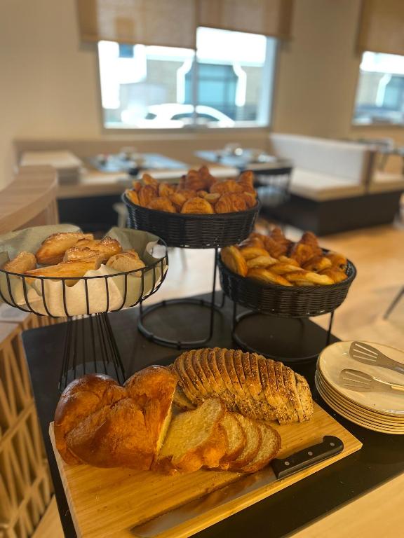 a table with three baskets of bread and pastries at Hôtel Restaurant BO &amp; MIA in La Baule