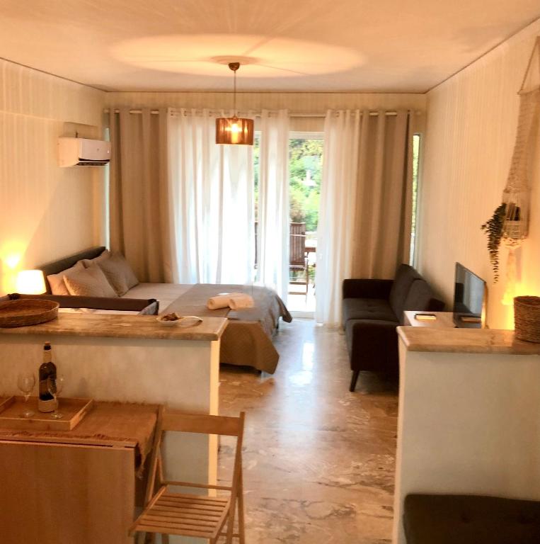 a living room with a bed and a couch at Studio στο Τολό in Tolo