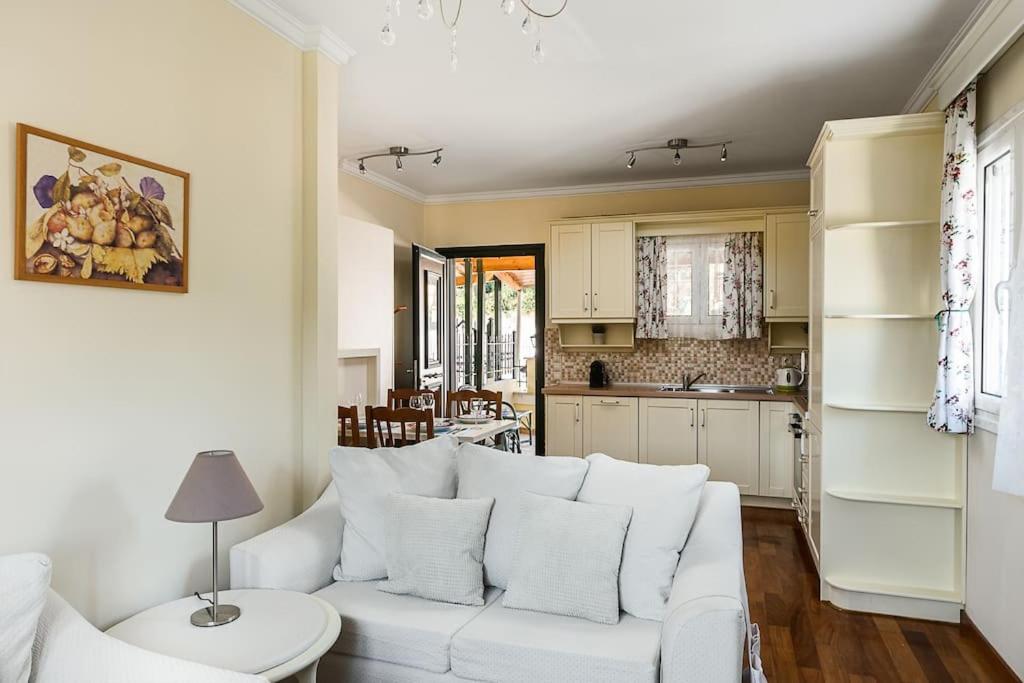 a living room with a white couch and a kitchen at Villa Nona in Acharavi