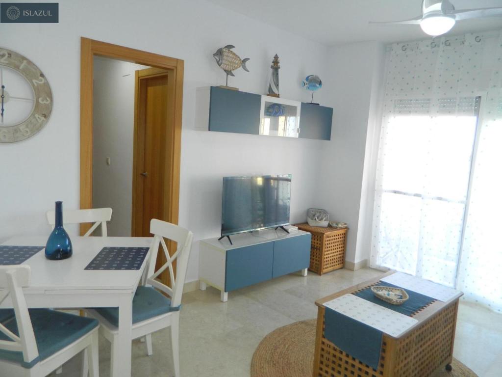 uma sala de estar com uma mesa e uma televisão em BLUE 470 em Isla Cristina