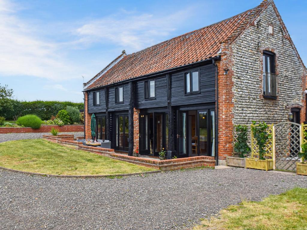 a brick house with a black facade at Oak Barn in Felbrigg