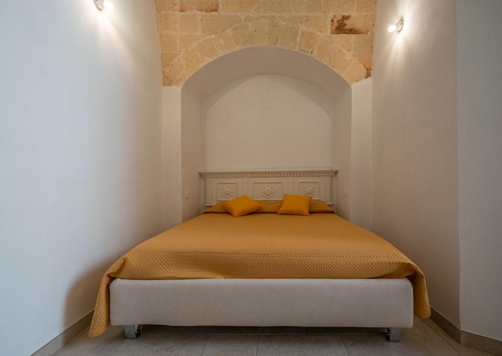a bed in a white room with an arch above it at CASA ALEF in Manduria