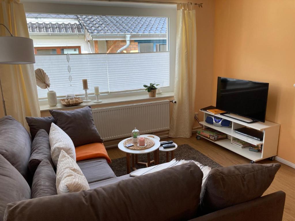 a living room with a couch and a television at Ferienhaus Stralsundia in Stralsund