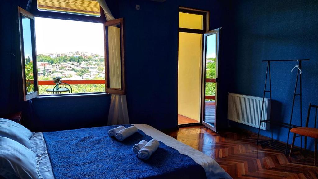 ein Schlafzimmer mit blauen Wänden und ein Bett mit zwei Handtüchern darauf in der Unterkunft Guesthouse ''Door'' in Sighnaghi in Sighnaghi