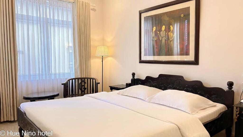 Giường trong phòng chung tại Hue Nino Hotel