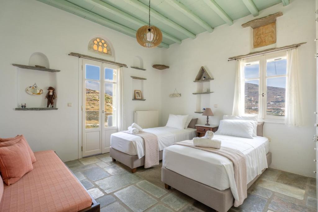 - une chambre avec deux lits et un canapé dans l'établissement Maison Simone with private heated infinity pool & spectacular sea view, à Agios Sostis