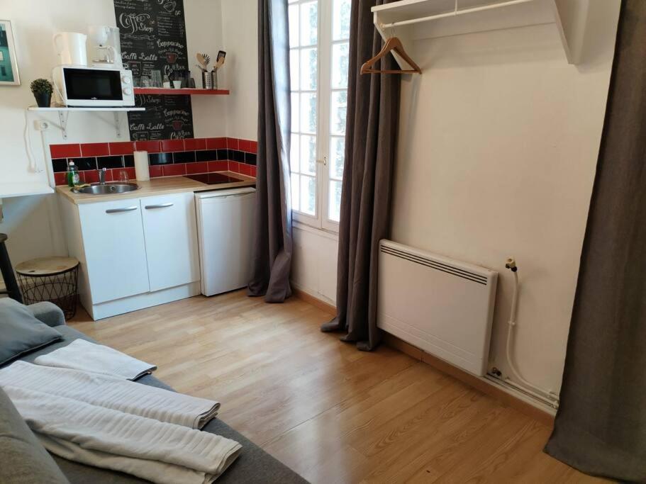 a room with a kitchen and a living room at Studio Rue de la Santé in Paris