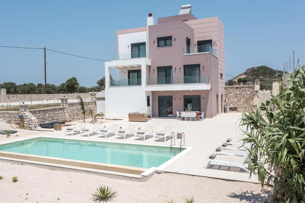 una villa con piscina frente a una casa en Villa Aurora, en Faliraki