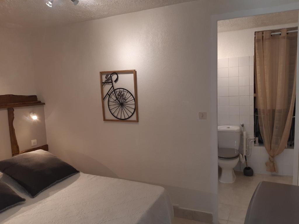 a bedroom with a bed and a picture of a bike on the wall at La ferme de Manon in Montferrat