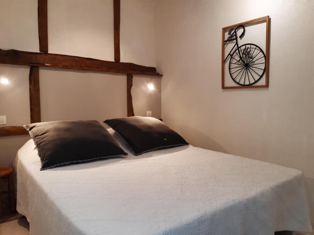 a bedroom with a bed with a bike on the wall at La ferme de Manon in Montferrat