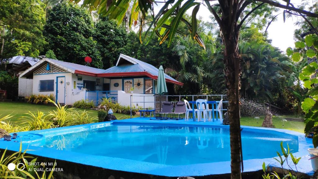a house with a swimming pool in front of a house at Sun House Rental in Mambajao
