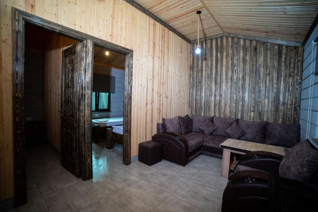 - un salon avec un canapé et une table dans l'établissement Arevik Resort Cottages, à Sevan