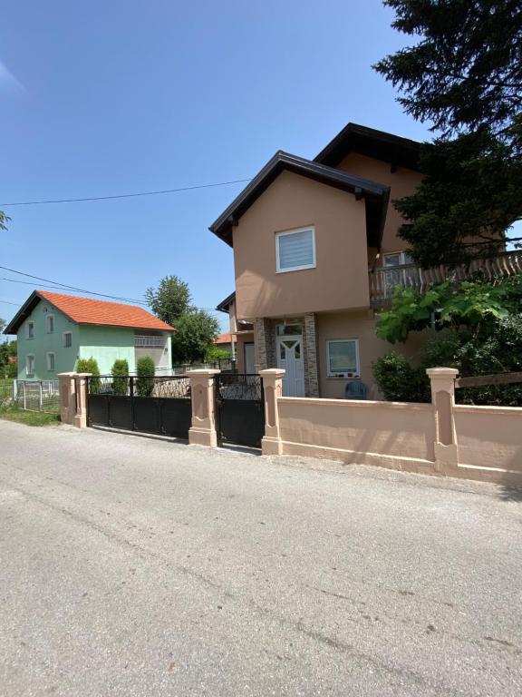 ein Haus mit einem Zaun am Straßenrand in der Unterkunft Villa Dalia in Sarajevo