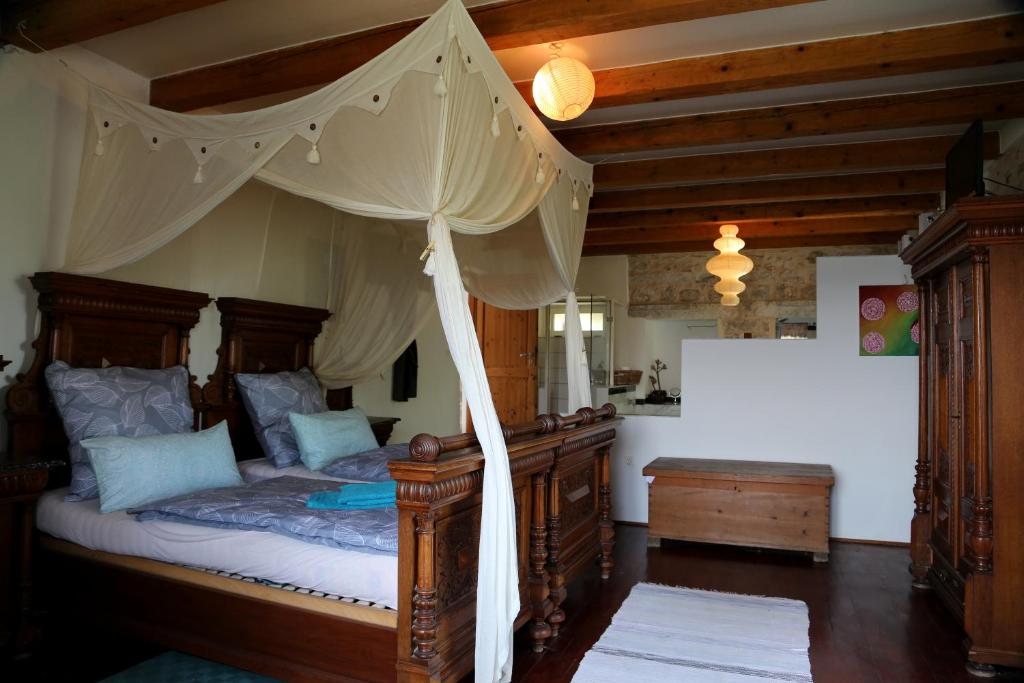 - une chambre avec un lit à baldaquin en bois dans l'établissement Eco Residence Rokotovi, à Stari Grad