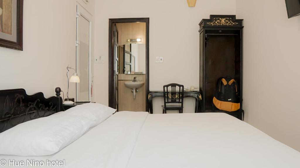 Postel nebo postele na pokoji v ubytování Hue Nino Hotel