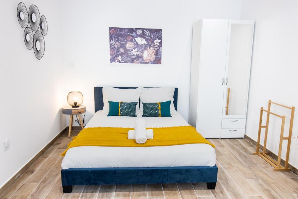 - une chambre avec un lit et une couverture jaune dans l&#39;établissement Charmant Studio Climatisé &#39;Alma 1&#39; - Béziers Centre - Wifi Fibre - Netflix, à Béziers