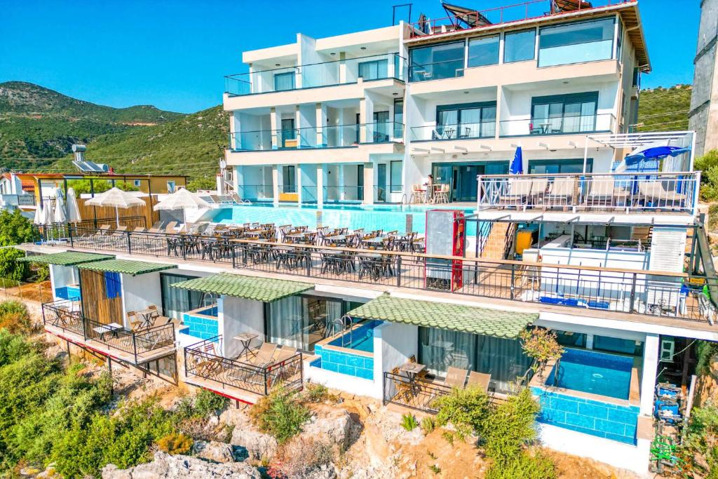 a large white building with balconies and tables at Stonehillkaş in Kas
