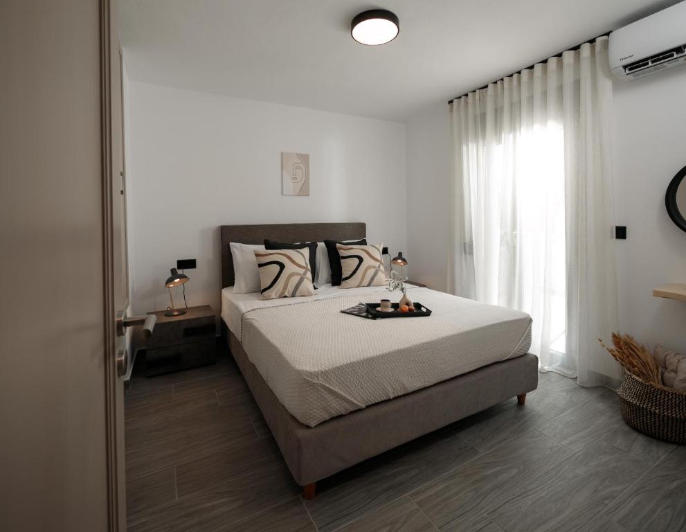 una camera con un grande letto e una finestra di Jannas Apartments Naxos a Naxos Chora
