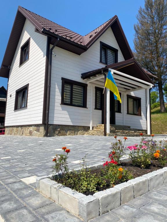 ein Haus mit einer Flagge davor in der Unterkunft Tomashchuk resort in Worochta