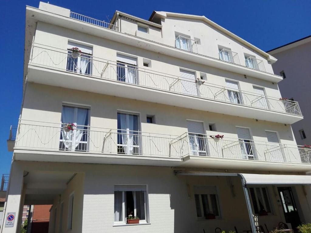 un edificio bianco con balconi e fiori di Hotel Villa Mon Reve a Rimini