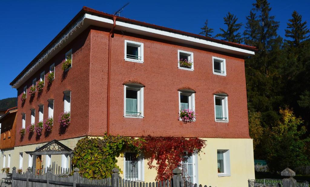 um edifício de tijolos vermelhos com flores nas janelas em Villa Vidal em Villabassa