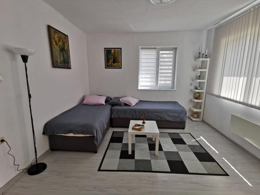 1 dormitorio con 2 camas y mesa en Mira Home en Veliko Tŭrnovo