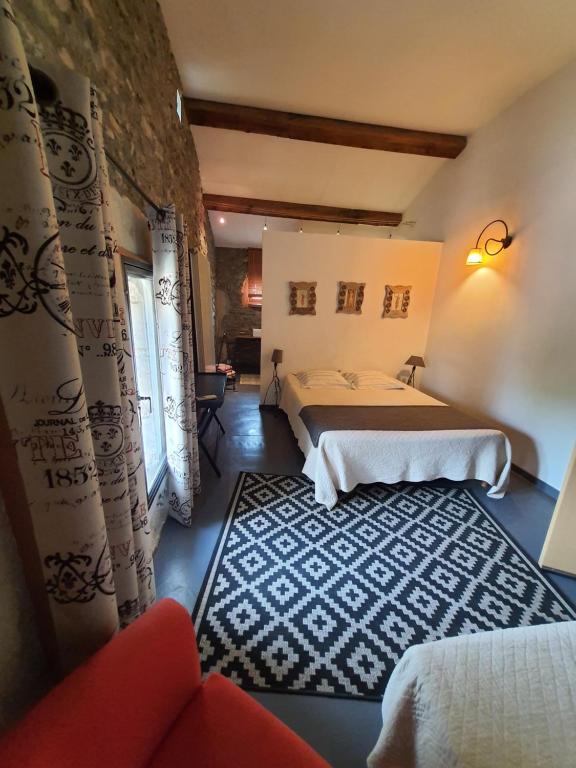 a hotel room with two beds and a rug at La Chamberte in Villeneuve-lès-Béziers