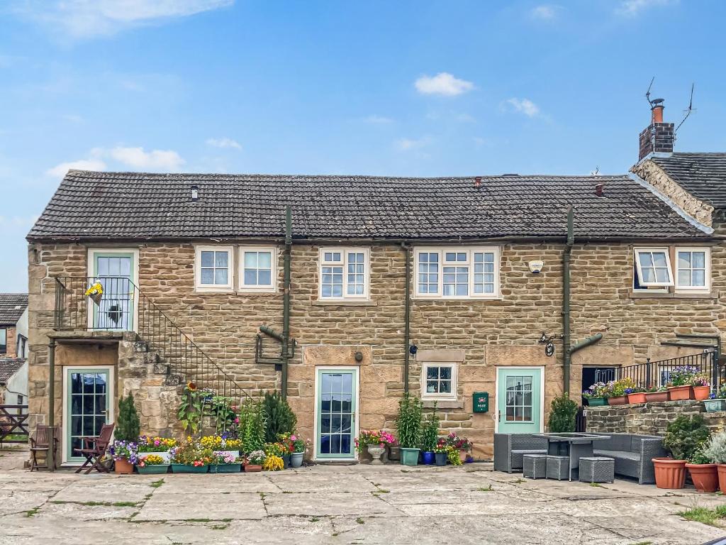 una grande casa in mattoni con finestre bianche di Ivy Cottage a South Wingfield