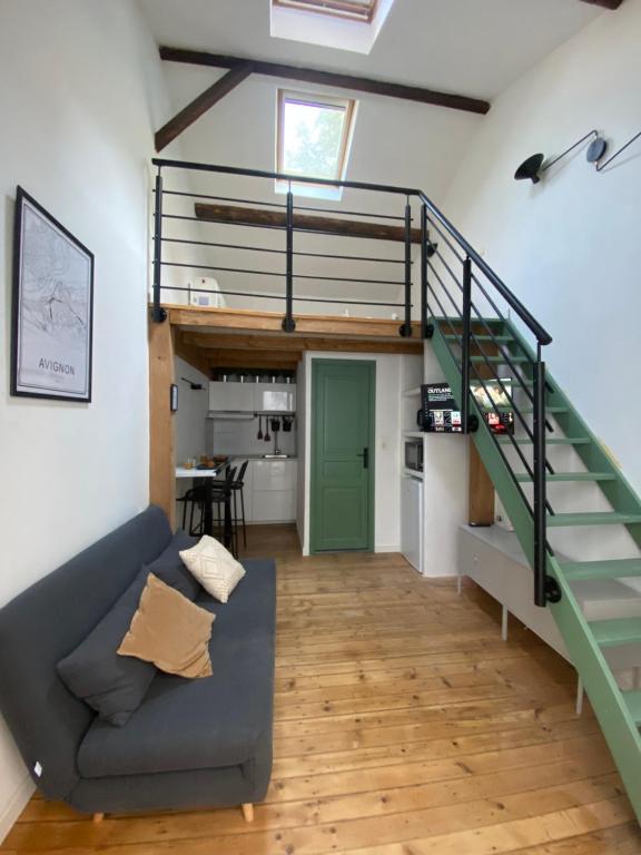 sala de estar con escalera y sofá en La Carretariá - Intra•muros - Wifi, en Aviñón